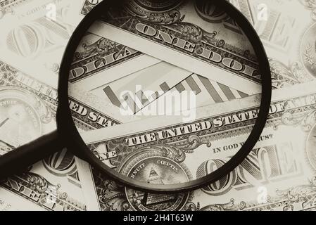 Dollars and currency chart under a magnifying glass close-up. Finance and the market. Exchange quotations. Black and white photography Stock Photo