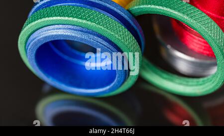 Green knurled nuts and colored router guide bushings detail on a black background with beautiful reflection. Close-up of anodized aluminum copy rings. Stock Photo