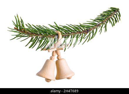 Two wood bells with star on natural Christmas twig isolated on white background. Closeup of Xmas decoration for happy New Year hanging on green branch. Stock Photo