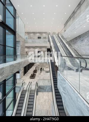 Interior atrium view with escalators. Courthouse Amsterdam, Amsterdam, Netherlands. Architect: KAAN, 2021. Stock Photo