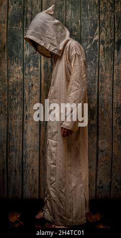 Tall man with long priest dress with wooden old wall Stock Photo