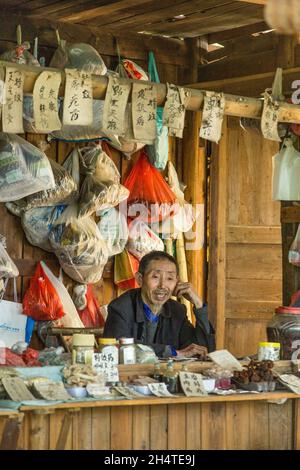 An older Chinese man selling traditional herbal medicines by a trail in Zhangjiajie National Forest Park, China. Stock Photo