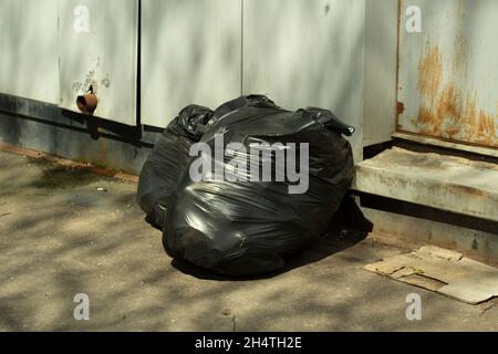 Garbage in bags. Black bags of waste. Plastic bags. Garbage collection by the road. Stock Photo