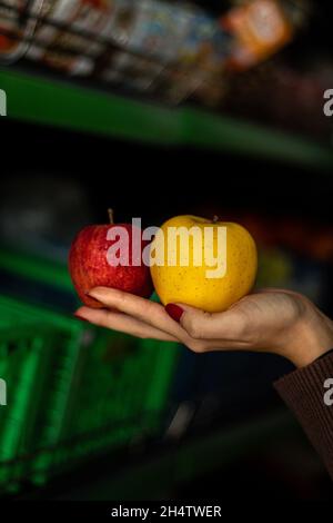 A female employee holding two apples for commercial. Stock Photo