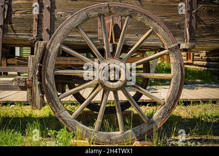 Old vintage, weathered wooden wagon wheel on wagon Stock Photo