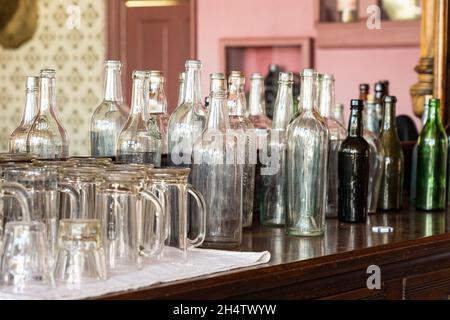 Old vintage whiskey bottles on the bar of am old wild west saloon Stock Photo