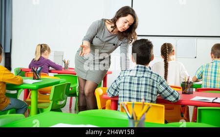 Female teacher scolding guilty student in elementary school class Stock ...