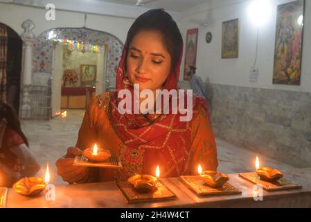 Pakistani Hindu community performing religious ritual during Diwali celebration at Shri Krishna Mandir in Lahore. Diwali (Deepavali) or Divali related to Jain Diwali, Bandi Chhor Divas, Tihar, Swanti, Sohrai and Bandna is a festival of lights and one of the major festivals celebrated by Hindus, Jains, Sikhs and some Buddhists. The festival usually lasts five days and is celebrated during the Hindu lunisolar month Kartika (between mid-October and mid-November). One of the most popular festivals of Hinduism, Diwali symbolizes the spiritual 'victory of light over darkness, good over evil, and kno Stock Photo