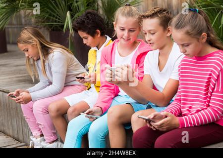 Five kids are playing on phone Stock Photo