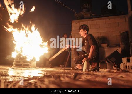 Gaza, Palestine. 04th Nov, 2021. Palestinian youth set a fire to keep themselves warm in Jabalia refugee camp in the northern Gaza Strip. Credit: SOPA Images Limited/Alamy Live News Stock Photo