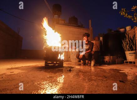 Gaza, Palestine. 04th Nov, 2021. A Palestinian man lights a fire to keep himself warm in Jabalia refugee camp in the northern Gaza Strip. Credit: SOPA Images Limited/Alamy Live News Stock Photo