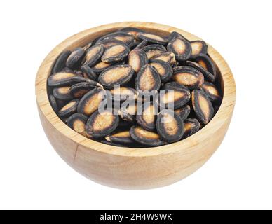 Black dry watermelon seeds in wooden bowl isolated on white background, Save clipping path. Stock Photo