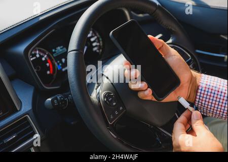 Charging smartphones in the car. Stock Photo