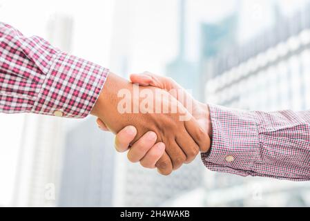 Civil engineer shaking hands with businessman on  urban city background. Stock Photo