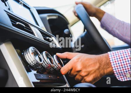 Close up male hand checking air conditioner in the car. The cooling system in the car. Stock Photo