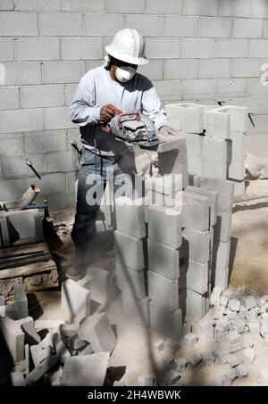 Concrete Mason cutting concrete block with a circular saw Stock Photo