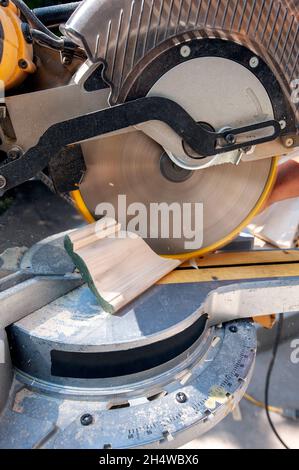 Finish carpenter using a compound slide miter saw to bevel crown molding Stock Photo