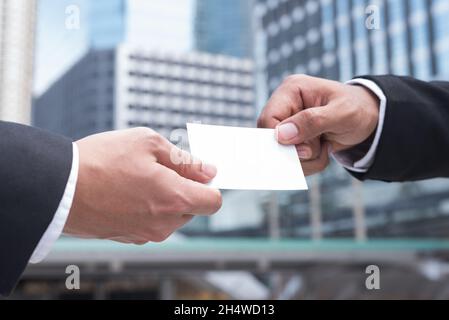 Hands of two businessman giving an empty business card Stock Photo