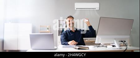 Air Conditioner Remote Control. Room AC In Modern Office Stock Photo