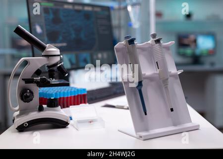 Nobody in research laboratory with micro pipette on desk. Empty scientific development room with professional equipment, microscope and lab glassware. Biochemistry cabinet with tools Stock Photo