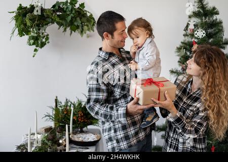 Mother gives Christmas gift to his little son for a New Year. Mom and son  opening Christmas presents Stock Photo - Alamy