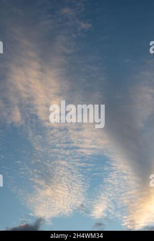 Fiery orange sunset sky and dramatic dark cumulus clouds, evening sky, vertical frame. Beautiful perfect sky for your photos. Heavenly background to o Stock Photo