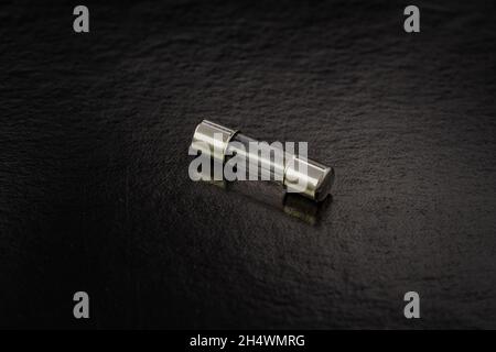 Blown cartridge electrical fuse on a black background Stock Photo