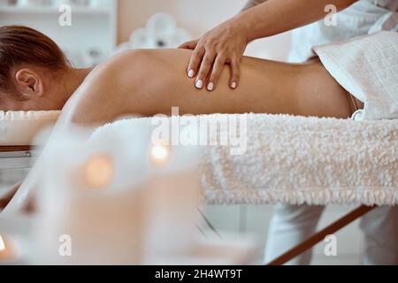 Professional confident massage master is doing procedures to caucasian woman in minimalistic modern cabinet Stock Photo