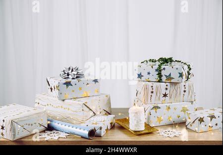 Minimalist Christmas presents background. Stacks of wrapped Christmas presents on table. Lower section filled and lot of copy space on upper section. Stock Photo