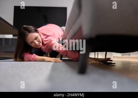 Woman Found Lost Cell Phone Under Couch Stock Photo