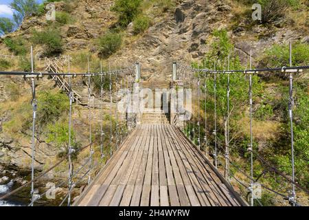 Suspension bridge made of wood and steel ropes over the Noguera Pallaresa river Stock Photo