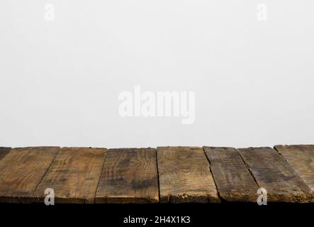 Wooden table top from rustic old wood planks with neutral gray wall background. Stock Photo