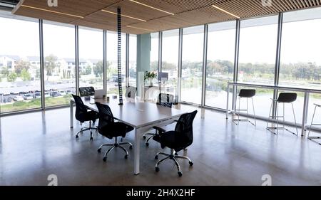 Empty black swivel chairs arranged around desk in modern office Stock Photo