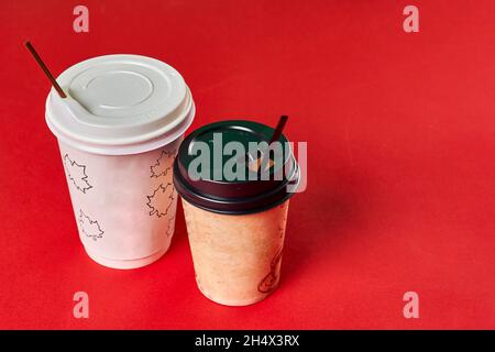 Two single-use plastic coffee cups on red background with copy space Stock Photo