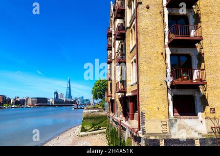 View of converted tea warehouse Oliver's Wharf on Wapping High Street with River Thames and the Shard in the background, Wapping, London, UK Stock Photo