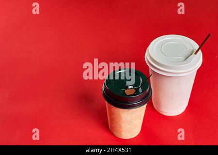 Two single-use plastic coffee cups on red background with copy space Stock Photo