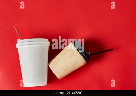 Two single-use plastic coffee cups on red background with copy space Stock Photo