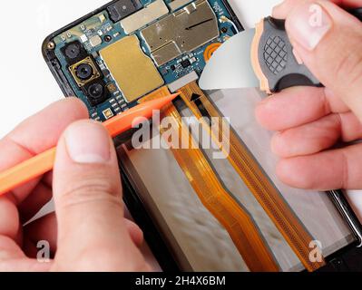 Close up hands of technician repairing smartphone do it yourself concept of computer hardware, mobile phone, electronic, repairing, upgrade and techno Stock Photo
