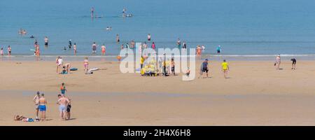 A panoramic image of holidaymakers enjoying the intense sunshine at Fistral Beach in Newquay in Cornwall. Stock Photo