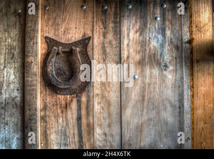 A retro horseshoe on a wooden wall in a countryside Stock Photo