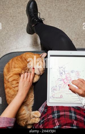 Caucasian female artist illustrator painting drawing on touch digital tablet with stylus Stock Photo