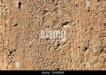 Old gray brown irregular concrete wall as background Stock Photo
