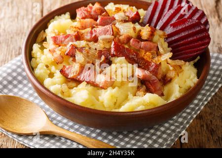 Burning love is a traditional Danish dish consisting of mashed potatoes topped with bacon and onions, both fried close-up in a bowl on the table. Hori Stock Photo