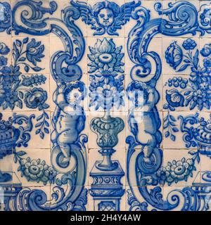 Traditional Portuguese, glazed ceramic wall tiles. Abstract background from old decorative painted Azulejos, religious theme with angels and flowers. Stock Photo