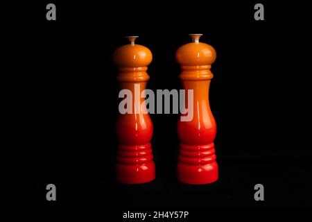 Front view of two luxurious salt and pepper mills and grinders isolated on a black background. Stock Photo