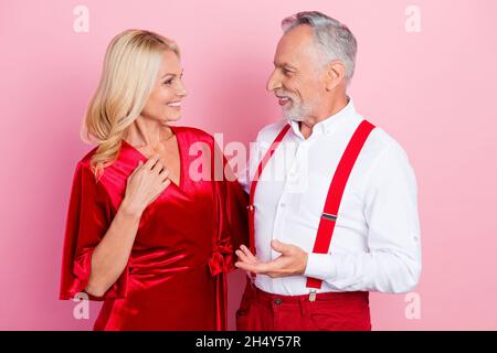 Portrait of two beautiful handsome cheerful spouses hugging talking having fun isolated over pink pastel color background. Stock Photo