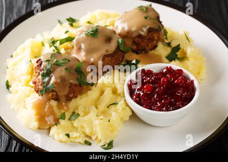 Meatballs Lihapullat with mashed potatoes and lingonberry jam close-up in a plate on the table. Horizontal Stock Photo