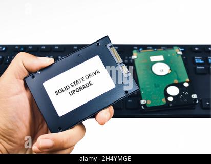 A technician shows a Solid State Drive (SSD) hard disk for a laptop computer upgrade Stock Photo
