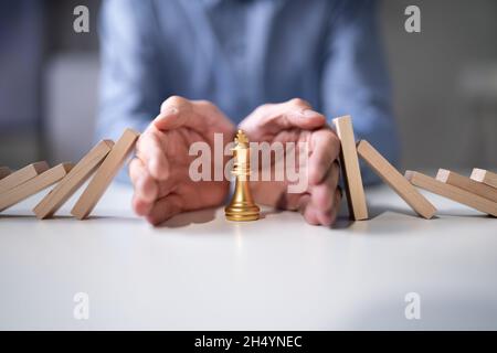 Falling Domino Pieces. Business Risk And Chess King Stock Photo