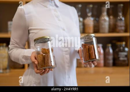 A woman holds a jar with Sweet pureed fruit pastila. Natural weight sweets in an eco store Stock Photo